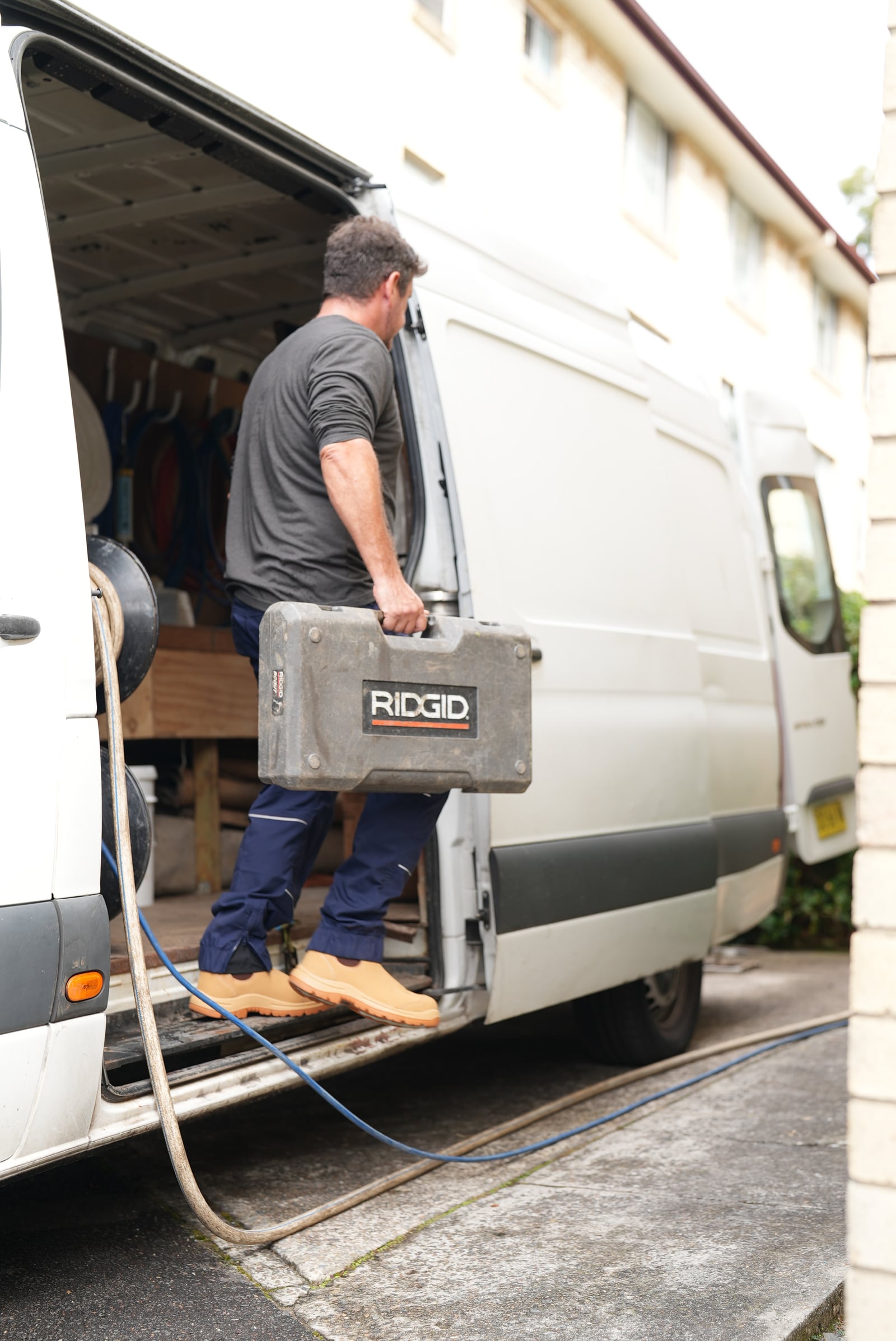 Drainr technician loading drain inspection equipment into the work van in Sydney