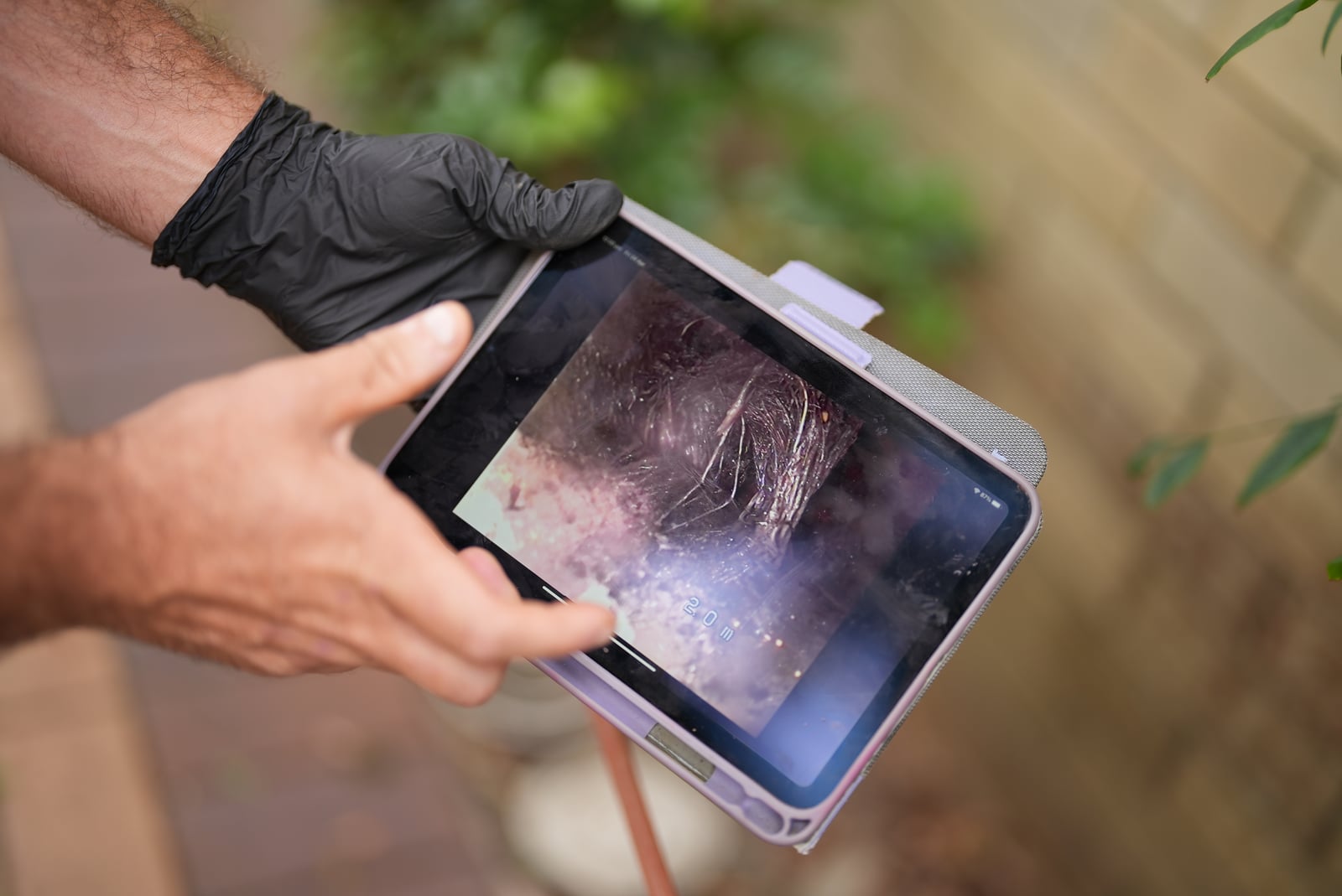 CCTV drain inspection footage on a tablet showing tree roots inside a Sydney sewer pipe